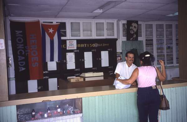 photo of Cuba, Cuban pharmacy with propaganda flag remembering the Cuban revolution and a picture of Che Guevara