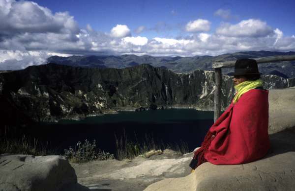 photo of Ecuador, Andes altiplano, Ecuadorean Indian woman sitting on the border of the Quilotoa volcanic crater lake (3570 m)