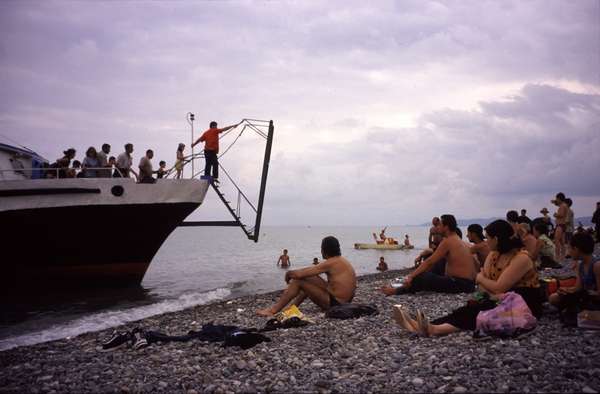 photo of Republic of Georgia, tourist boat mooring on the beach of Batumi with Georgians sunbathing