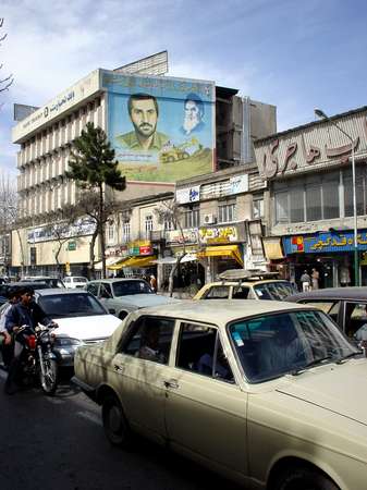 photo of Iran, Tehran (Teheran), street with paykans and billboard commemorating Khomeini and the martyrs of the Iran Iraq war