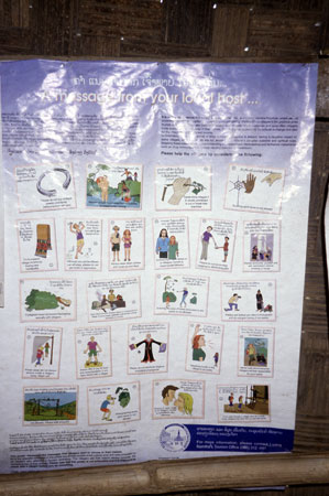 photo of Laos, Nong Khiaw, board with cartoons portraiting guidelines for tourists : "a message from your local host" : "it is forbidden to cut or break tree branches inside Akha villages", "speaking loudly is not polite", "never walk alone", "walk around spirit gates", "don't get drunk on Lao whisky"