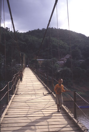 photo of Laos, Muang Khua village, Laotian child walking on a hang bridge over the Nam Ou River
