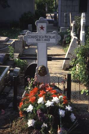 photo of Romania, Bucharest, the tiny grave with red star of Nicolae Ceausescu (Ceaucescu), the once mighty communist dictator, hidden among bigger graves on the Ghencea cemetery 