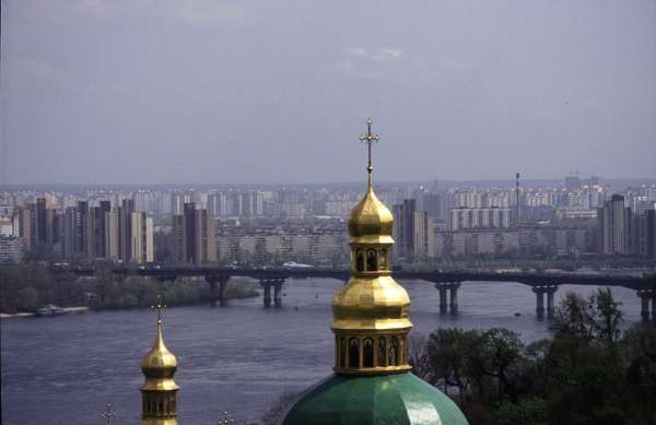 photo of Ukraine, Kiev (Kyiv), apartment blocks and bridge over the Dniepr (Dnipro, Dnieper) river seen from one of the green and gold church domes of the Caves Monastery (Pechersk Lavra)