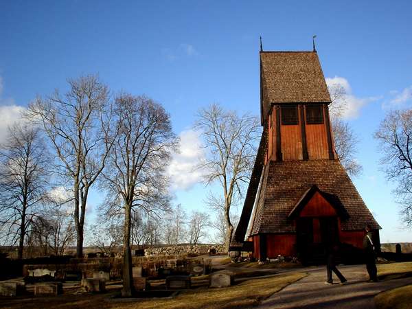 photo of Sweden, Old Uppsala, old red wooden church and graveyard in Gamla Uppsala