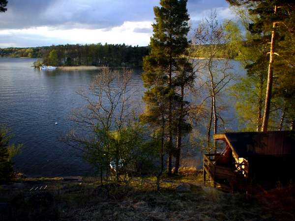 photo of Sweden, Stockholm area, view of lake Mälaren from a stuga (Summer House) on the tiny island of Kanan with in the background the island of Ekerö, the little wooden hut built close to the water is the bastu (Swedish sauna) a must in every summerhouse in Sweden