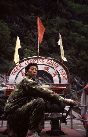 photo of China, Yunnan province, around Lijiang, Chinese boatsman on a tiny ferry which crosses the Tiger Leaping Gorge